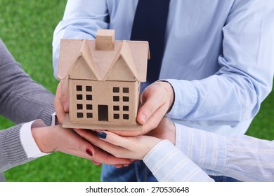 Group Of Businesspeople Holding Model House