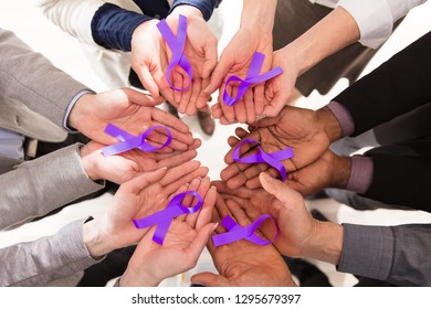 Group Of Businesspeople Holding Teal Ribbons To Support Pancreatic Cancer Awareness