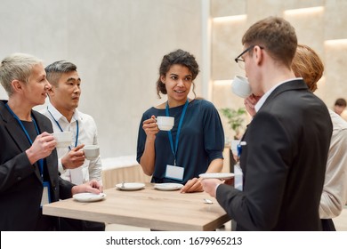 Group of businesspeople interacting during coffee break at business conference. Business, communication concept. Horizontal shot. Selective focus - Powered by Shutterstock