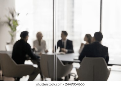 Group of businesspeople negotiating gathered in modern conference room, blurred silhouettes view, meeting behind closed glass doors. Business communication, workflow, decision-making, strategy sharing