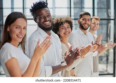 Group of businesspeople sitting in a line and applauding. - Shutterstock ID 2208314471