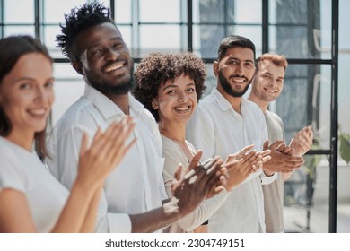 Group of businesspeople sitting in a line and applauding. - Shutterstock ID 2304749151