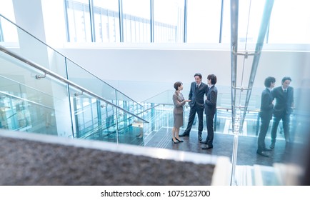 Group of businesspeople standing at the landing of the stairs.