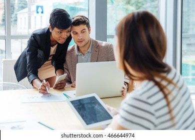 Group of businesspeople working with laptop, tablet and cell phone on business meeting - Shutterstock ID 466644974