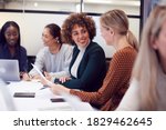 Group Of Businesswomen Collaborating In Creative Meeting Around Table In Modern Office