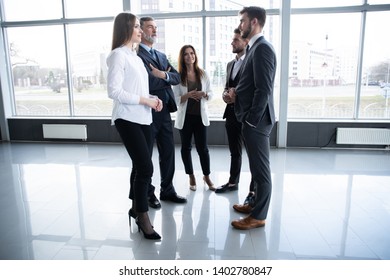 Group Of Busy Business People Concept. Business Team Discussing Work In Office Building Hallway