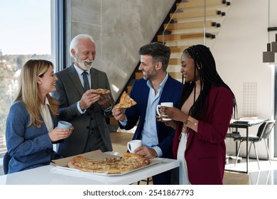 A group of Caucasian and African business colleagues share a relaxed moment with pizza and coffee in a sunlit office setting. - Powered by Shutterstock