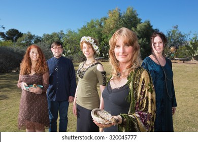 Group of Caucasian polytheists with smudge sticks standing outdoors