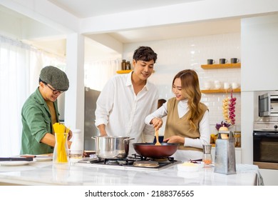Group Of Cheerful Asian Man And Woman Enjoy Cooking And Talking Together In The Kitchen At Home. Happy People Friends Having Dinner Party Meeting Celebration Event Eating Food On Holiday Vacation