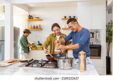 Group Of Cheerful Asian Man And Woman Enjoy Cooking Healthy Food Together In The Kitchen At Home. Happy People Friends Reunion Meeting Party And Celebration Event Having Dinner On Holiday Vacation