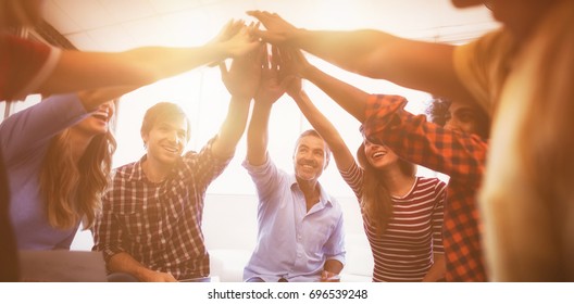Group Of Cheerful Business People Giving High Five While Sitting Creative Office