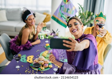 Group Of Cheerful Friends In Carnival Costumes Celebrating Mardi Gras And Taking Selfie With Smart Phone. 