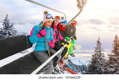 Group Of Cheerful Friends Are Lifting On Ski-lift For Skiing In The Mountains