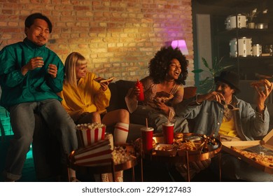 A group of cheerful friends are in a retro styled living room, wearing fashionable clothes and enjoying takeout food. - Powered by Shutterstock