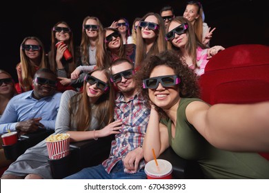 Group of cheerful friends wearing 3D glasses smiling happily taking a selfie relaxing at the cinema together happiness memories people entertainment activity recreation concept. - Powered by Shutterstock