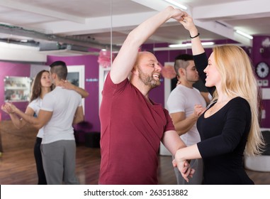 Group Of Cheerful Happy Young Adults Dancing Salsa In Club