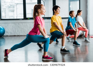 Group Of Cheerful Kids Doing Stretching In Gym