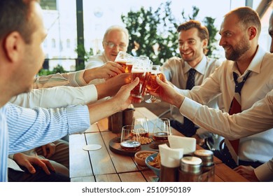 Group of cheerful men, business people meeting at outdoor cafe, clinking glasses with lager beer and celebrating successful deal. Concept of business, meeting, celebration, leisure time, Oktoberfest - Powered by Shutterstock