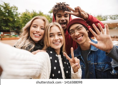 Group if cheerful multiethnic friends teenagers spending fun time together outdoors, taking a selfie - Powered by Shutterstock