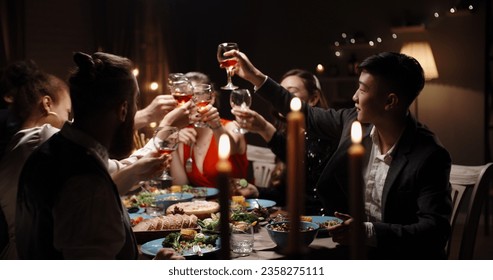 Group of cheerful multiethnic student friends are celebrating birthday together. Positive people having dinner for event, eating vegan mediterranean food  - Powered by Shutterstock