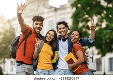 Group Of Cheerful Multietnic College Friends Posing Together Outdoors, Happy Smiling Students Having Fun And Laughing, Relaxing After Classes, Looking At Camera And Showing Peace Gesture - Powered by Shutterstock