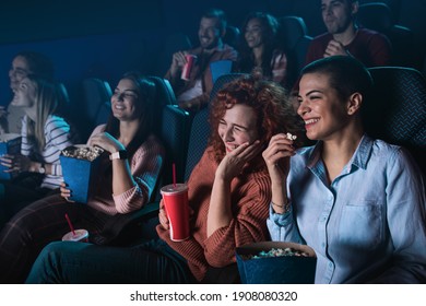 Group of cheerful people laughing while watching movie in cinema. - Shutterstock ID 1908080320