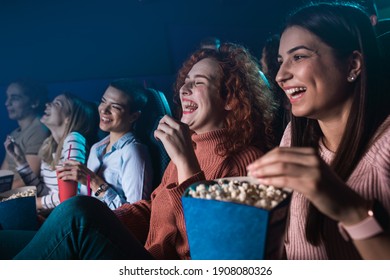 Gruppe fröhlicher Leute, die beim Kinoschauen lachen.