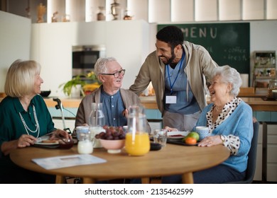 Group of cheerful seniors enjoying breakfast in nursing home care center. - Powered by Shutterstock