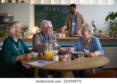 Group of cheerful seniors enjoying breakfast in nursing home care center. - Powered by Shutterstock