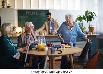 Group Of Cheerful Seniors Enjoying Breakfast In Nursing Home Care Center.