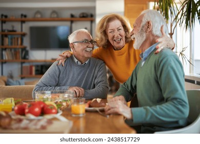 Group of cheerful seniors friends talking while having breakfast at the table - Powered by Shutterstock