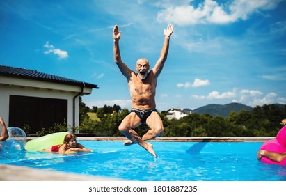 Group of cheerful seniors in swimming pool outdoors in backyard, jumping. - Powered by Shutterstock