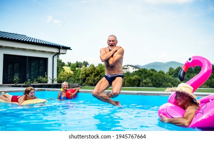 Group of cheerful seniors in swimming pool outdoors in backyard, jumping. - Powered by Shutterstock