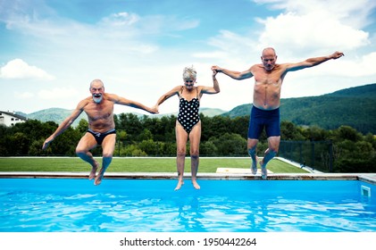 Group of cheerful seniors in swimming pool outdoors in backyard, jumping. - Powered by Shutterstock