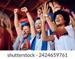 Group of cheerful sports fans celebrating victory of their favorite team while spectating game from stadium stands. Focus is on African American woman.