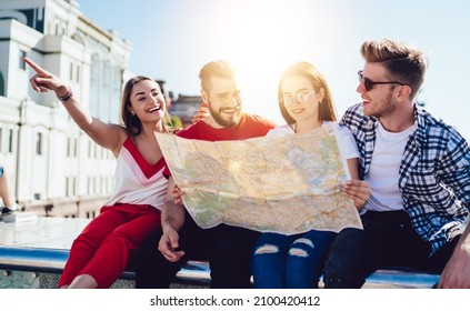 Group Of Cheerful Tourists Using Travel Map For Search Direction Route And Explore City During Summer Vacations, Happy Caucasian Hipster Guys With Orientation Paper Discussing Funny Journey Trip