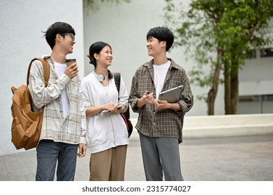 A group of cheerful young Asian college students enjoy talking and sharing their ideas while walking in the campus outdoor space. Education concept - Powered by Shutterstock