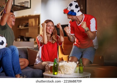 Group of cheerful young football fans watching the game on TV, celebrating victory after their team has scored a goal  - Powered by Shutterstock