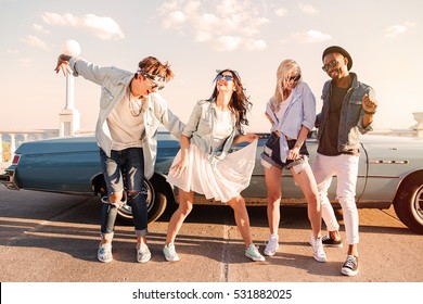 Group Of Cheerful Young Friends Dancing Together Outdoors