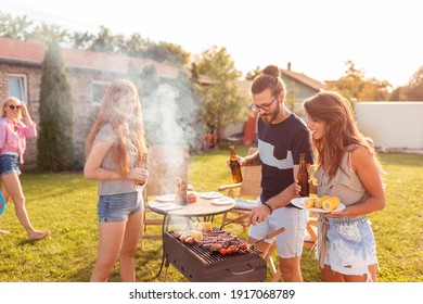 Gruppe von fröhlichen jungen Freunden mit Grillparty im Hinterhof, Grillfleisch, Bier trinken, Badminton spielen und sich an einem sonnigen Sommertag im Freien entspannen