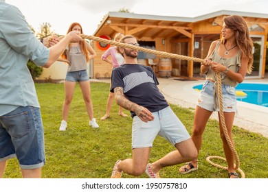 Group Of Cheerful Young Friends Having Fun At Summertime Outdoor Party By The Swimming Pool, Participating In Limbo Dance Contest, Passing Below The Rope While Dancing