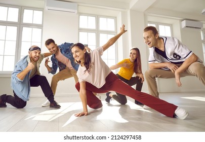 Group Of Cheerful Young People Dancing And Having Fun. Happy Street Dancer Crew Practising Together In A Studio. Team Of Excited Friends Cheering And Supporting Young Girl Who's Doing A New Dance Move