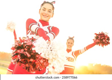 Group Of Cheerleaders Performing Outdoors  - Concept Of Cheerleading Team Sport Training At High School During Sunset - Tilted Horizon Composition And Warm Filter With Sun Backlighting