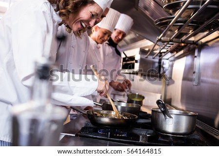 Group of chef preparing food in the kitchen of a restaurant