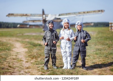 Group Of Children Of Aviators. Teenagers In The Clothes Of Pilots. Children In The Street Military Airport