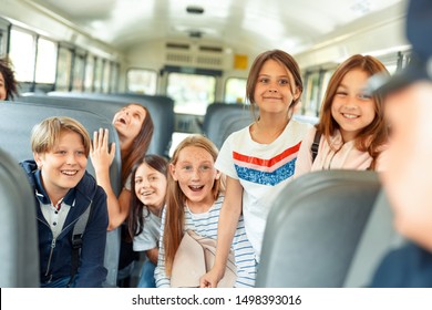 Group of children classmates going to school by bus sitting inside talking interacting with driver smiling cheerful - Powered by Shutterstock