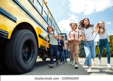 Group Of Children Classmates Running From School Bus Going Back Home Looking Forward Smiling Excited