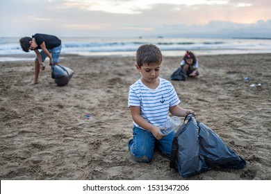 Group Of Children Collecting Plastic On A Beach