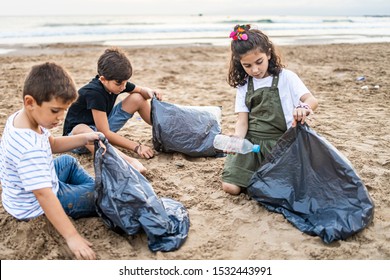 Group Of Children Collecting Plastic On A Beach