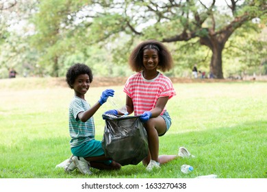 Group Of Children Are Collecting Trash Into A Black Bag, Kids Volunteer Charity Environment.